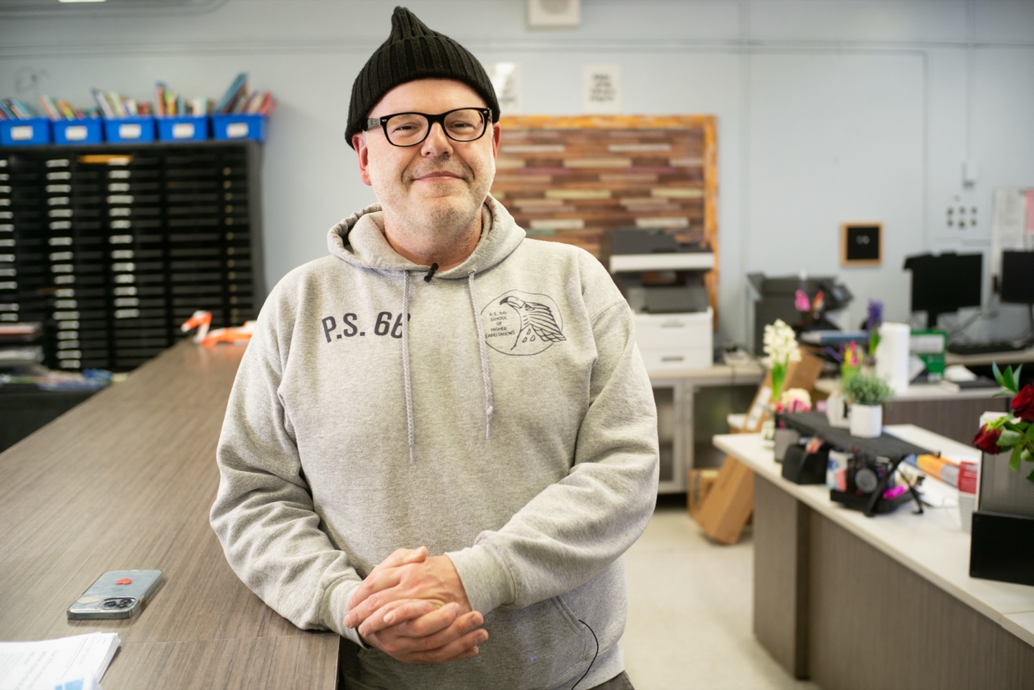 A staff member smiling behind the front desk of a program space