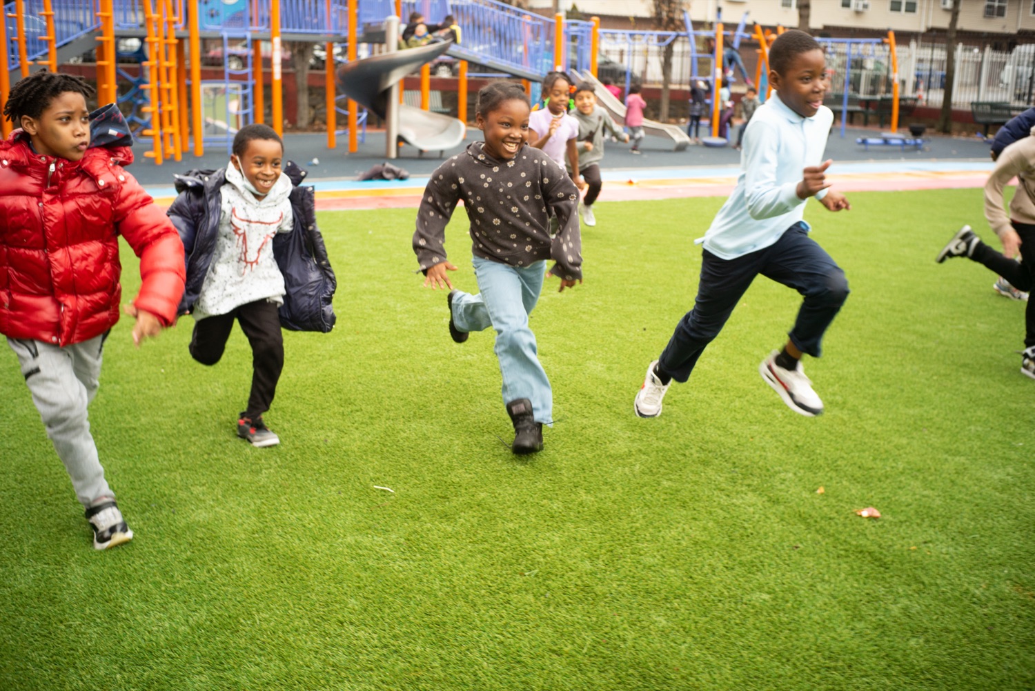 Kids racing across the turf at a playground