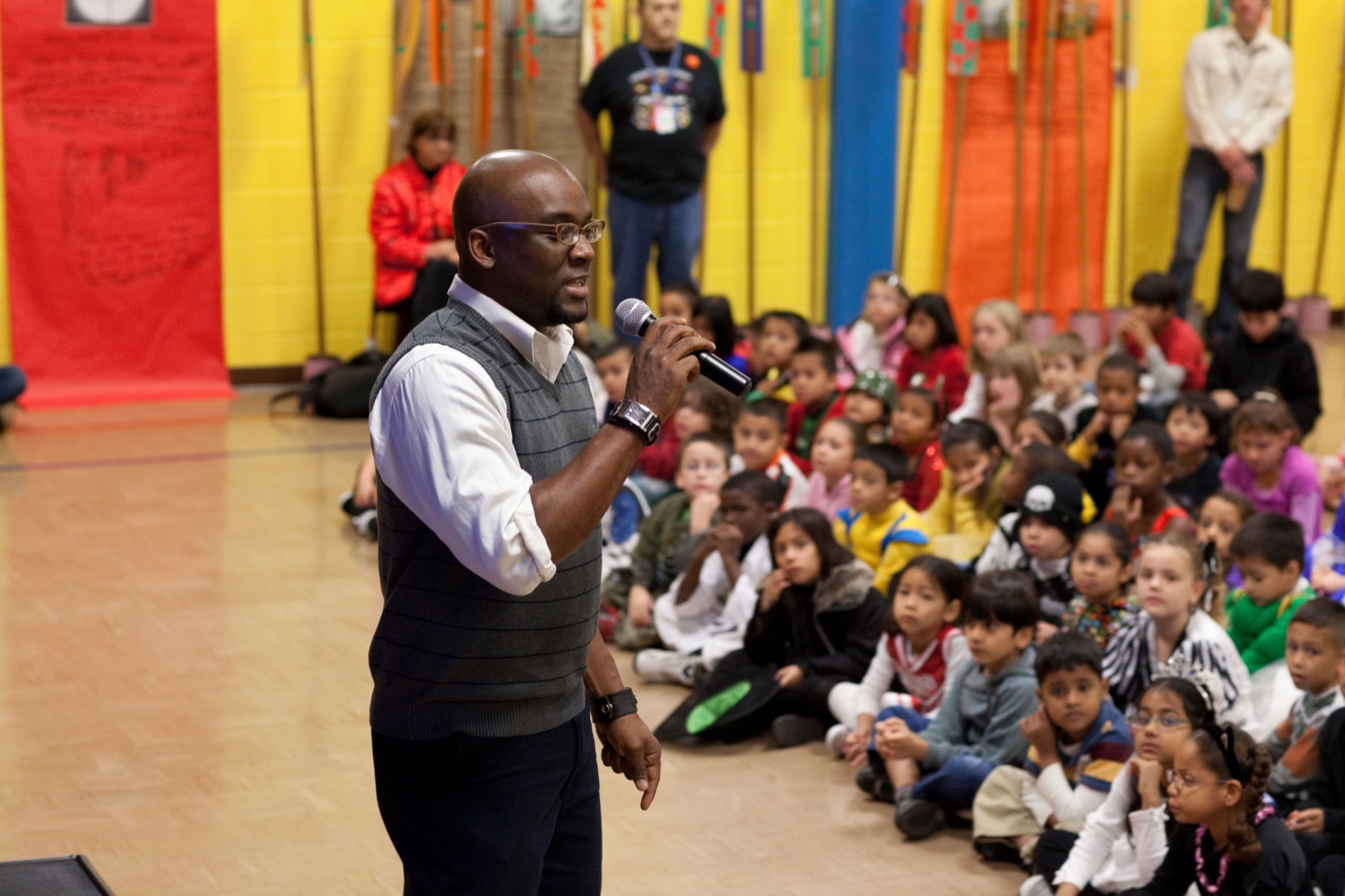 A program leader speaking to a room full of kids
