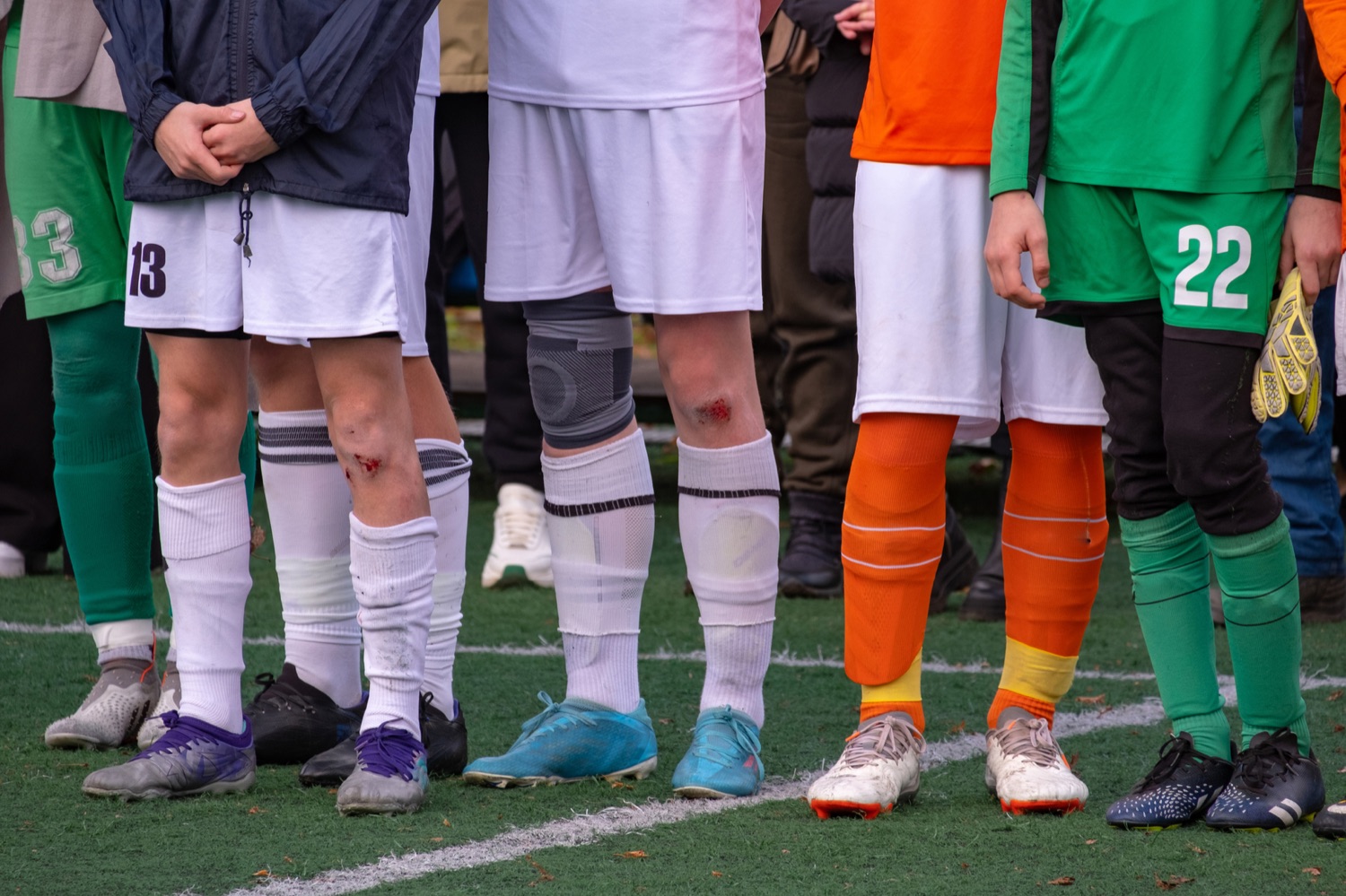 Young players lined up on the turf before a game