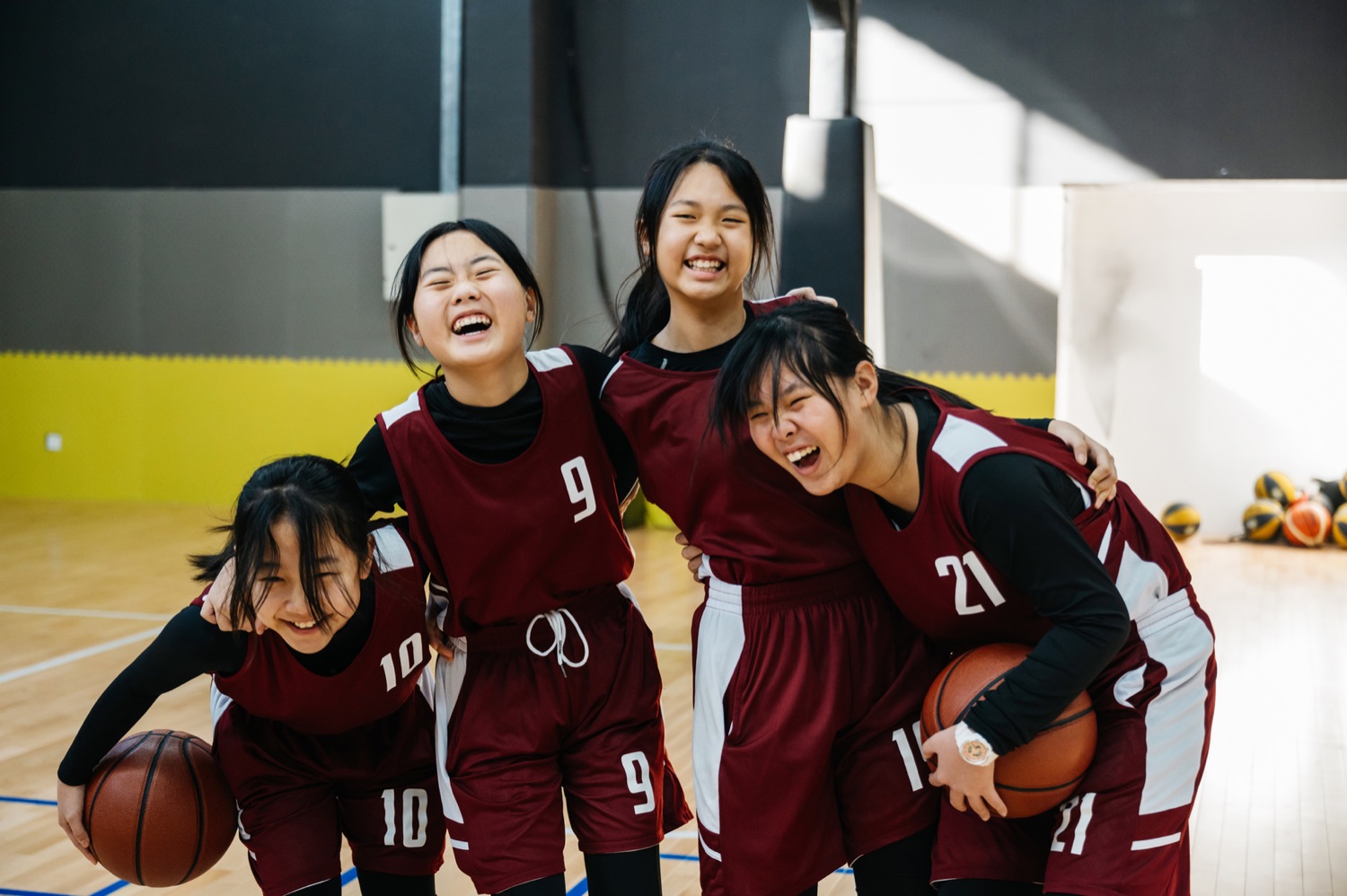 A youth basketball team laughing together in the gym